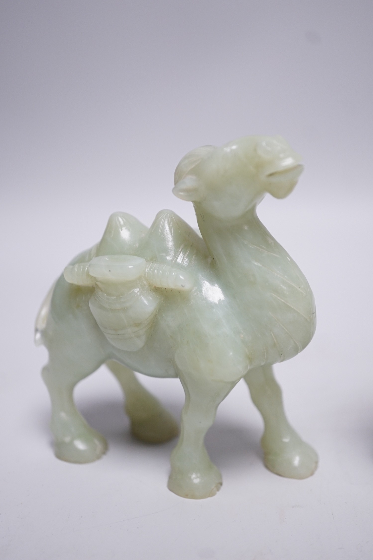 Three Chinese bowenite jade carvings of a Bactrian camel, a Pekinese dog and Shou Lao, tallest 12cm